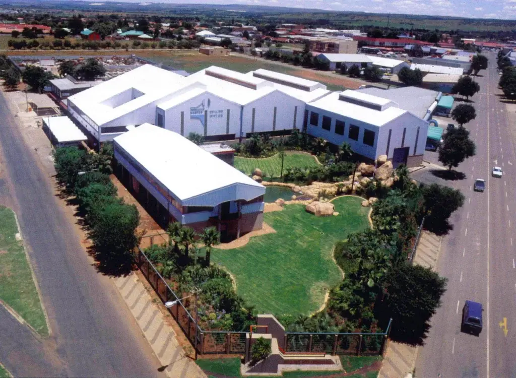 Aerial view of a landscaped Master Drilling campus with white buildings and green grounds.