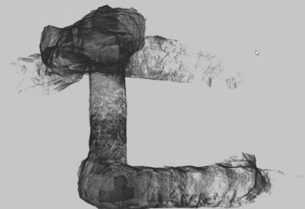 A grayscale 3D visualization shows a complex duct system with bends and turns, resembling a right-angled pipe structure. The texture appears to be rough, with varying shades highlighting the intricate surface details, and parts look partially transparent.